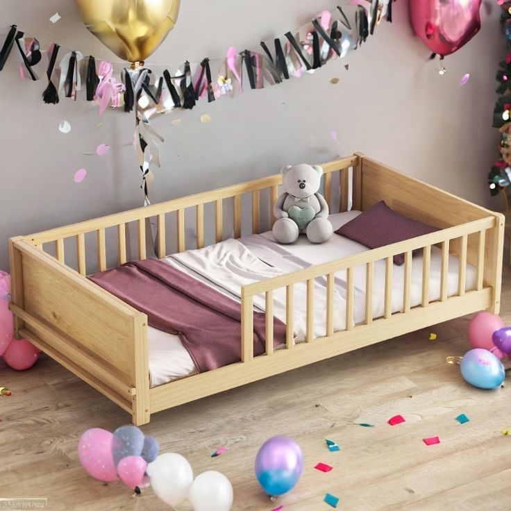 a baby's crib with balloons and streamers