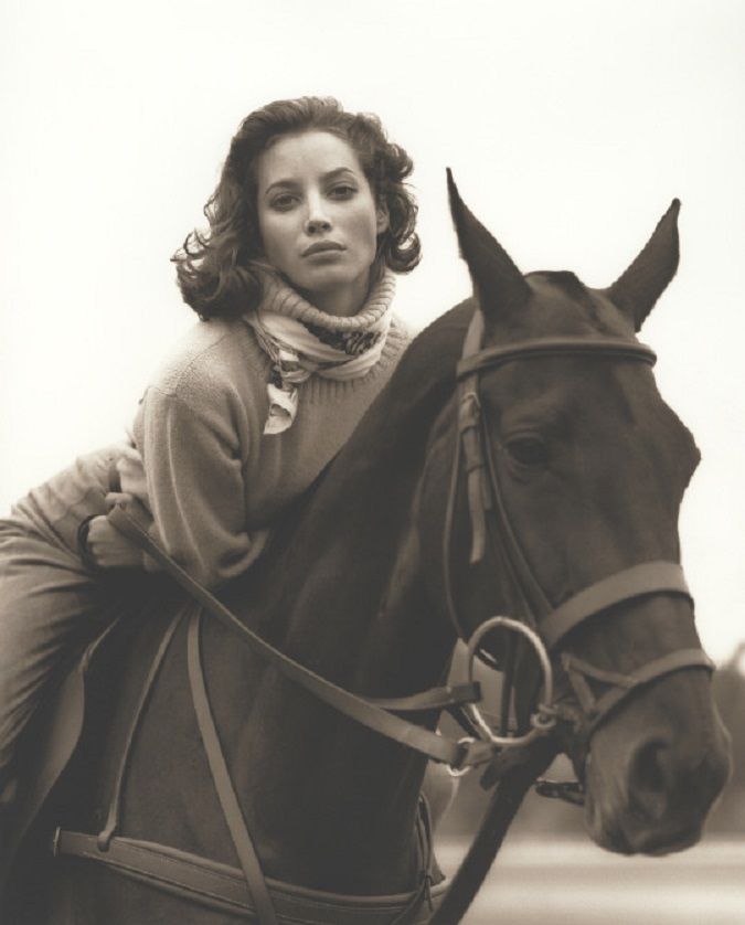 a woman riding on the back of a brown horse