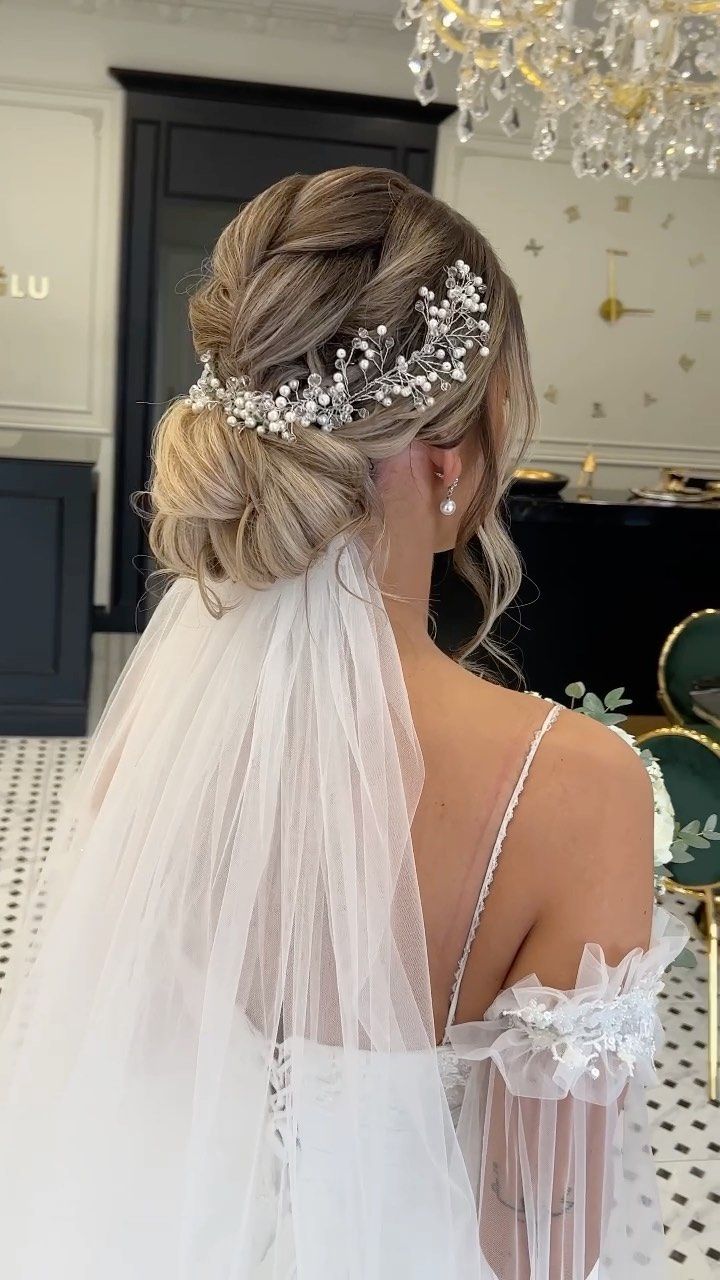 the back of a bride's dress with a veil on her head