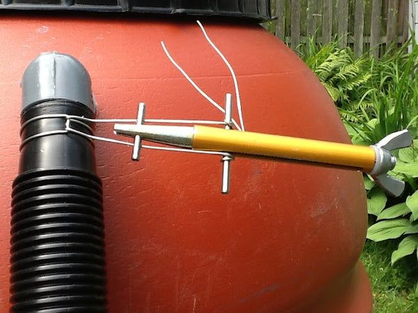 a large red ball with a yellow handle attached to it and a tool sticking out of the top