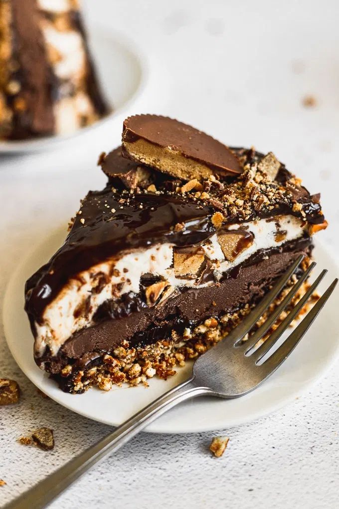 a piece of triple fudge peanut butter cup ice cream cake on a plate with a fork