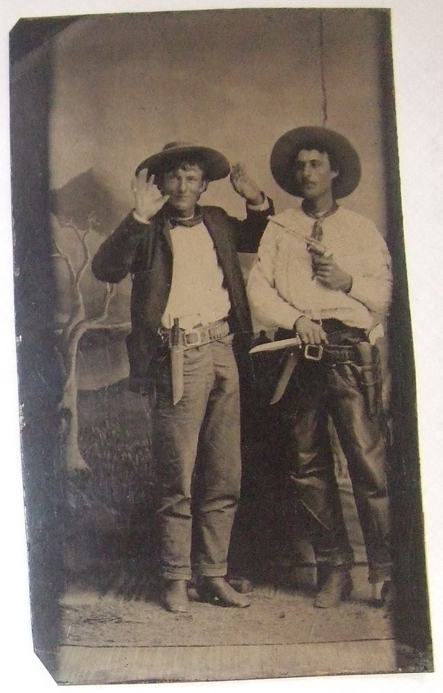 an old black and white photo of two men in cowboy hats standing next to each other