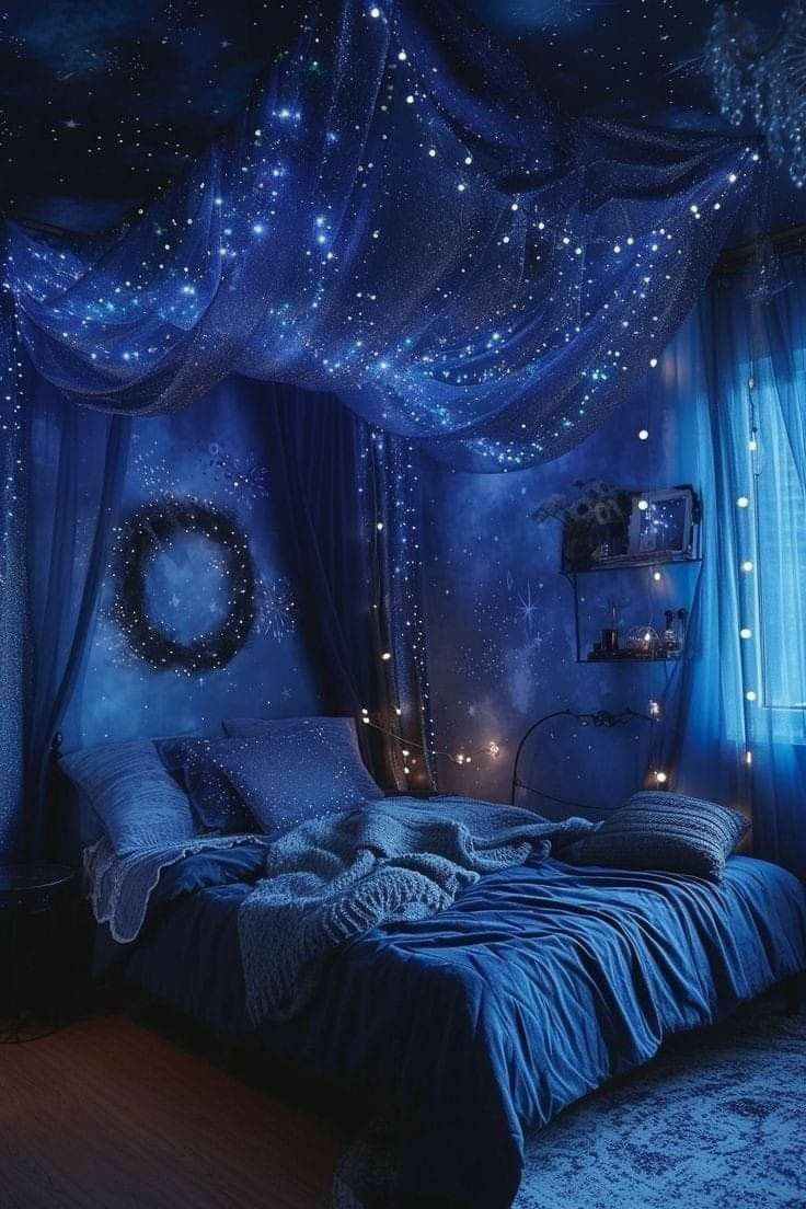 a bedroom decorated in blue with stars on the ceiling and curtains hanging from the ceiling