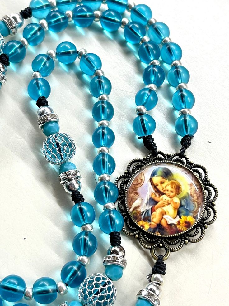 Welcome to my shop, Creating Still Moments Please visit my shop for other listings and opportunities to complete your holiday shopping  Thanks for visiting My entire Etsy shop is currently 20% off if you're looking to do some holiday shopping  https://www.etsy.com/shop/CreatingStillMoments?ref=sh-carousel-1  Handmade Rosary Immaculate Mary and Jesus bronze centerpiece Blue Glass beads blue mesh Pater beads  Indulgence bronze crucifix Blue rosary Catholic gift  Catholic gift confirmation gift God Rosary Mary, Immaculate Mary, Bronze Centerpiece, Wedding Rosary, Rosary Making, Jewellery Making Tutorials, Blue Rosary, Rosary Prayer, Godparent Gifts