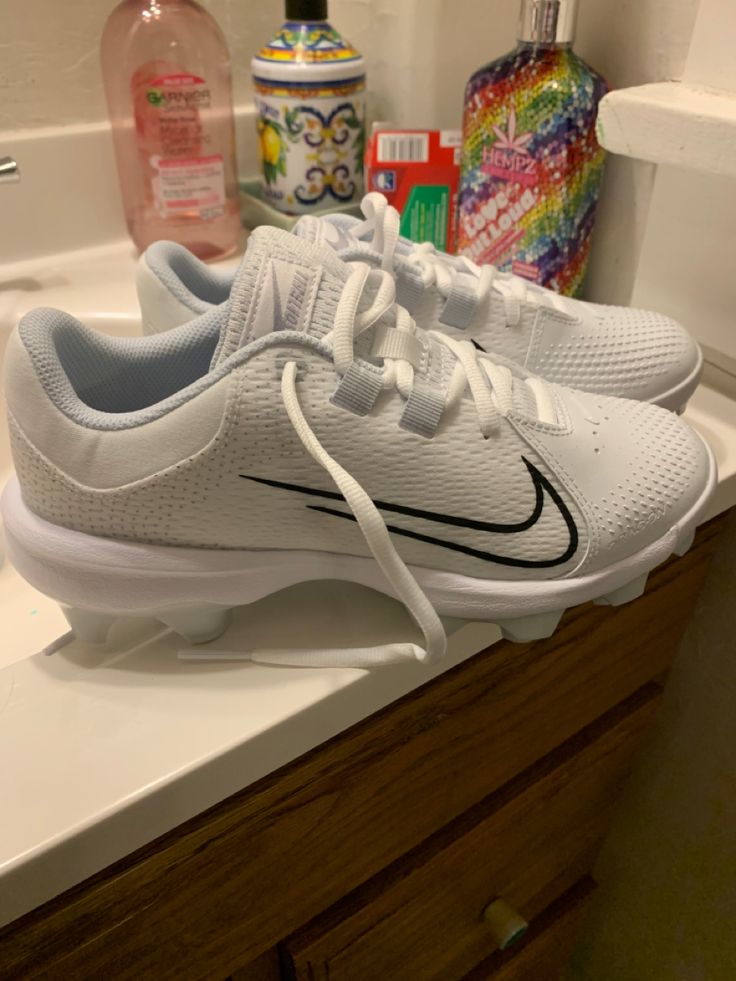 a pair of white shoes sitting on top of a bathroom counter