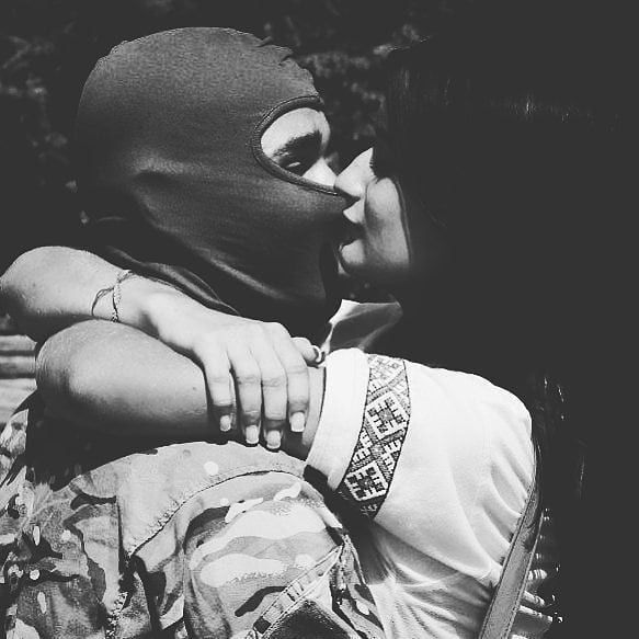 a man and woman kissing while sitting on a bench