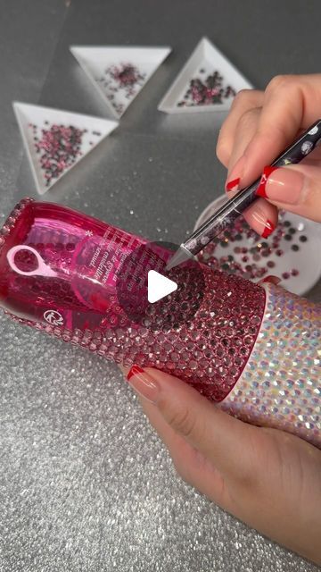 a woman is using scissors to cut the inside of a bottle with sequins