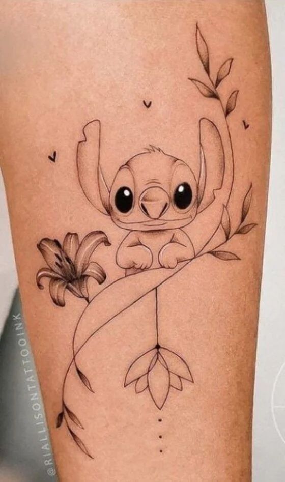 a tattoo with an image of a baby slotty on it's leg and flowers