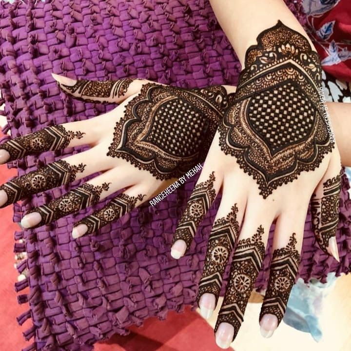 a woman's hands with hennap on it and purple fabric in the background