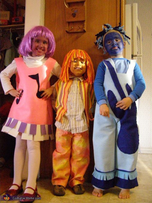 three children in costumes standing next to each other