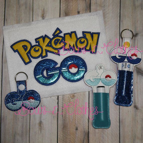 the pokemon go keychain is next to some other items on a wooden surface