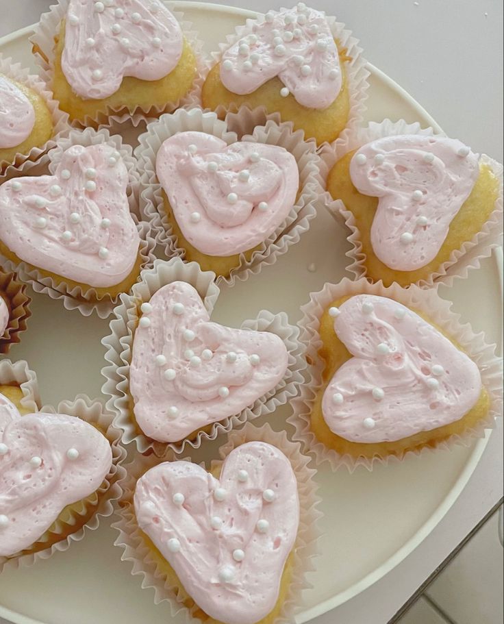 cupcakes with frosting in the shape of hearts on a plate