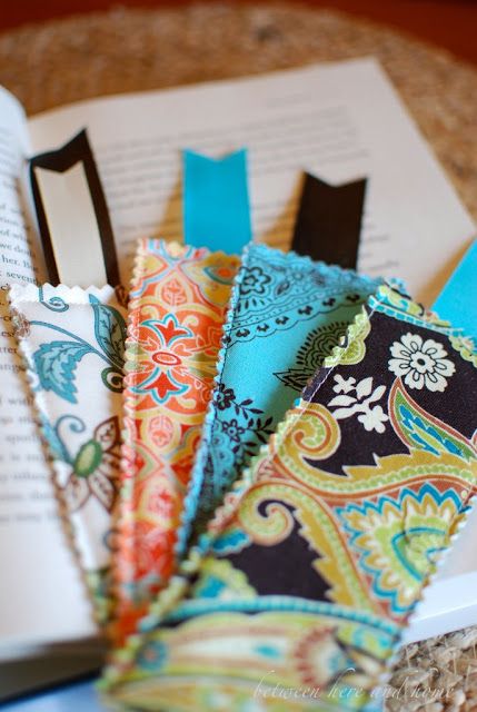 an open book sitting on top of a table next to some colorful ties and scissors