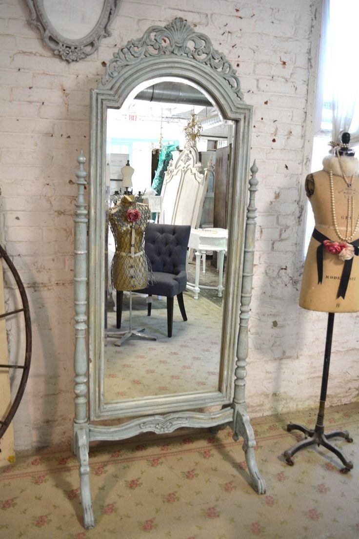 a large white mirror sitting on top of a wooden floor next to a mannequin