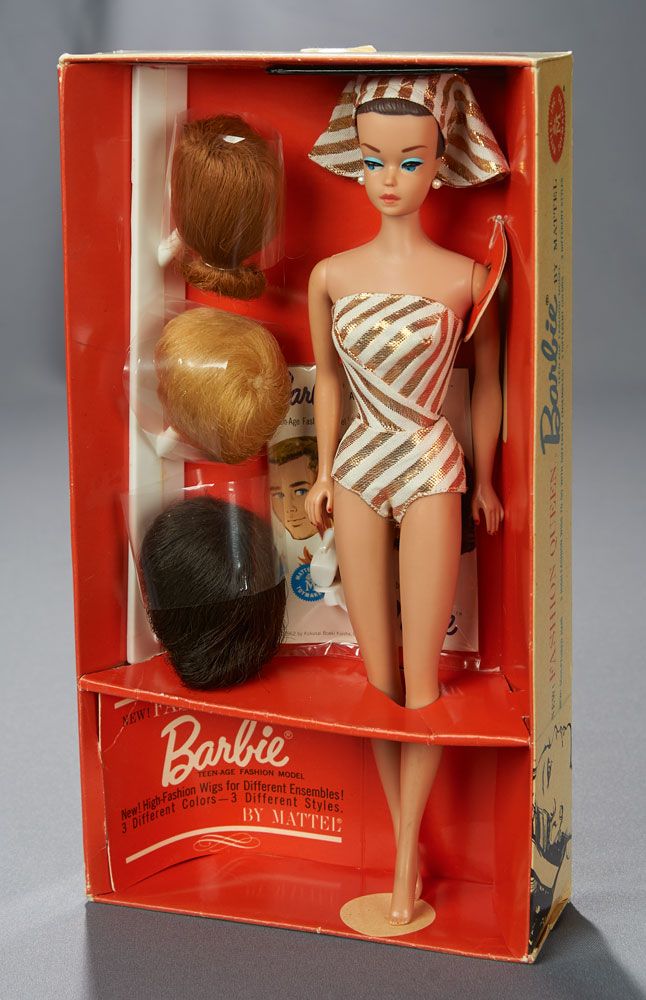 a barbie doll in a bathing suit and hat with other dolls inside it's box