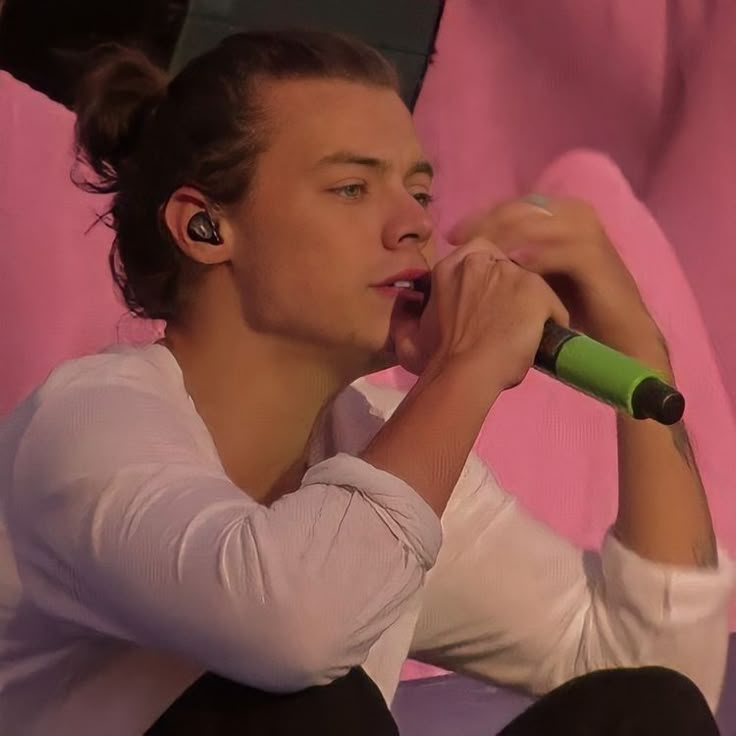 a woman with ear buds sitting on a pink couch