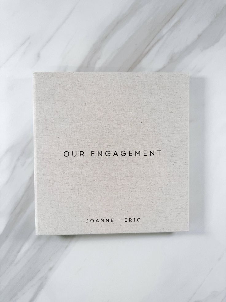 the book our engagement by joannne eric on a marble surface with black lettering