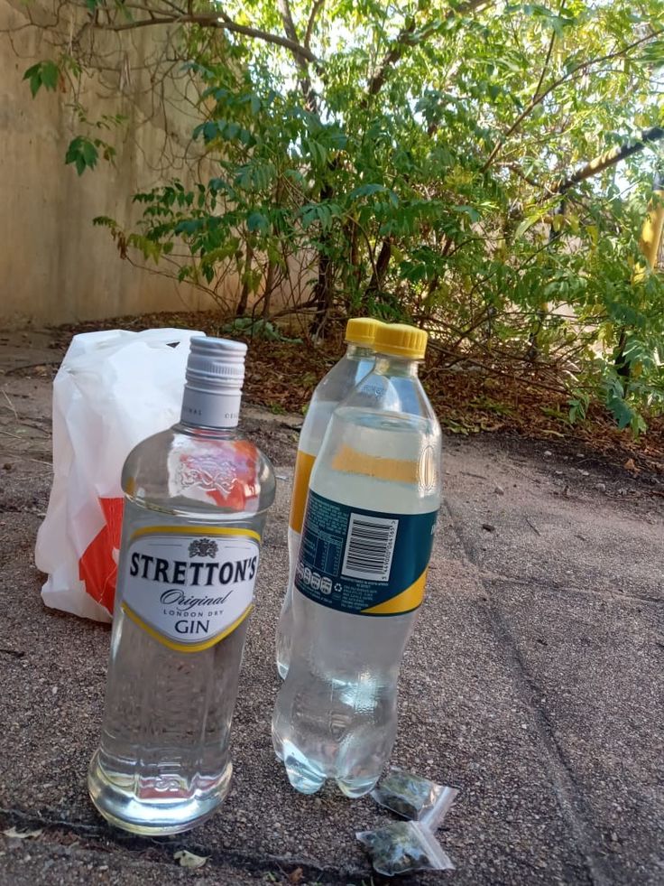 two bottles of water sitting on the ground