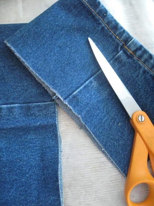 a pair of scissors sitting on top of a pair of jeans