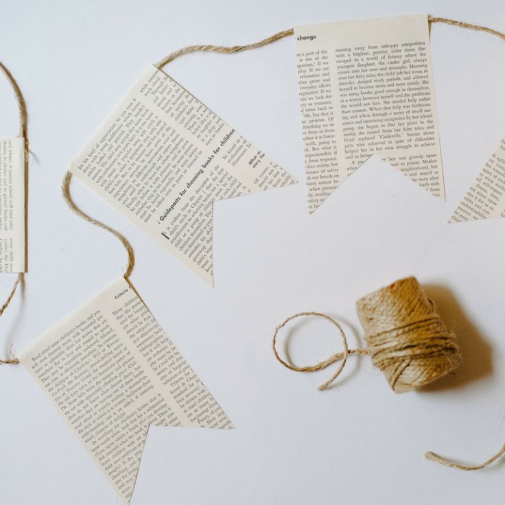 several pieces of paper with twine tied to them on top of each other next to some books