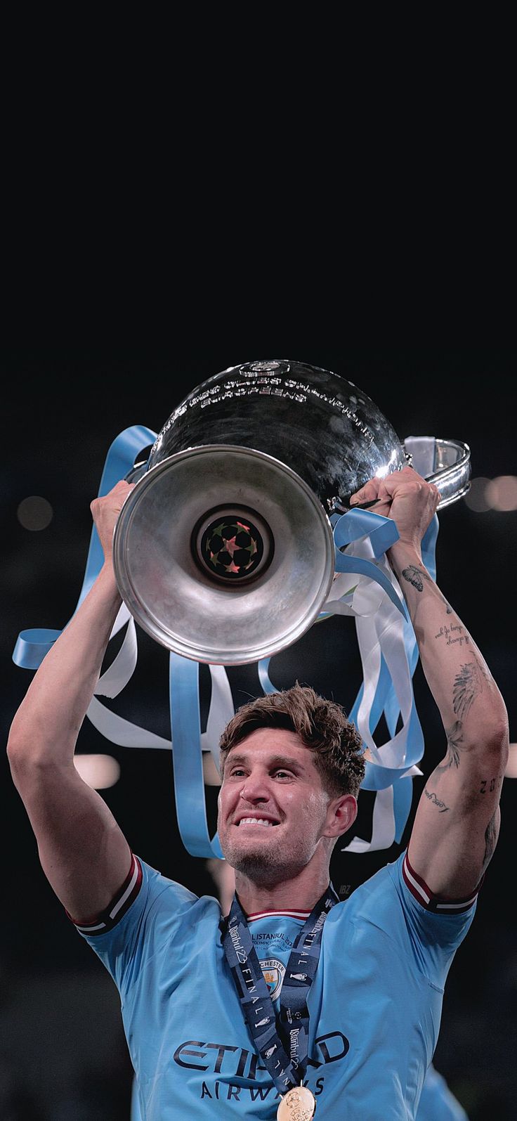 a man holding up a silver trophy in the air with his hands on top of it