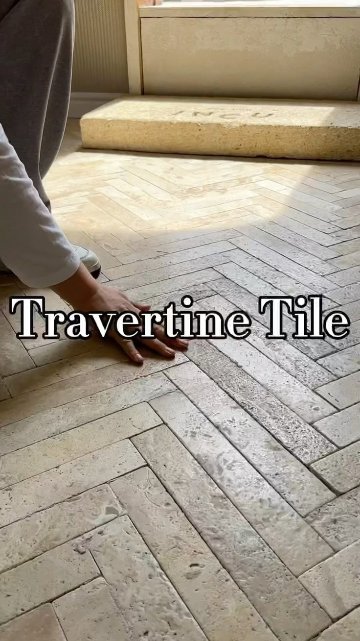 a person kneeling down on the ground with their feet in the floor and text that reads, travertime tile