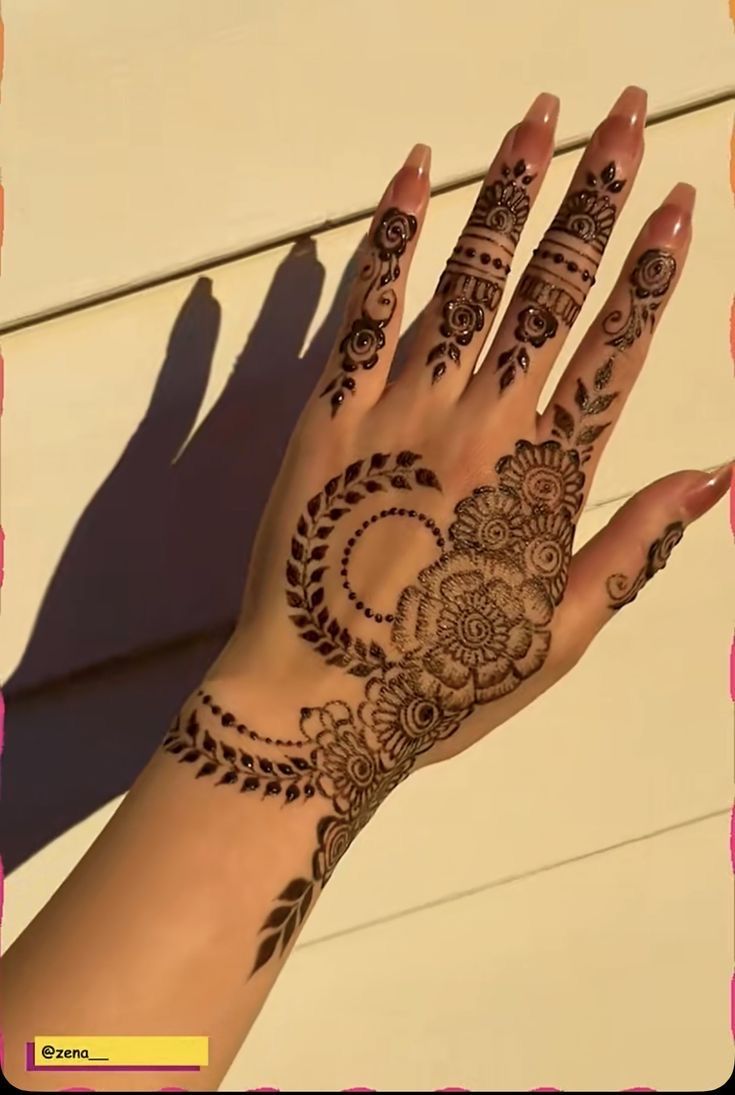 a woman's hand with henna tattoos on it