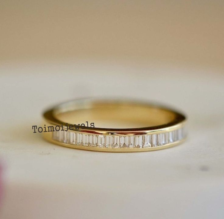 a wedding band with baguettes on it sitting on top of a white table