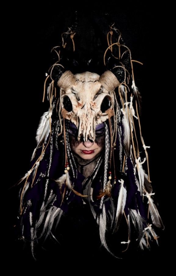 a woman with long hair wearing a horned mask