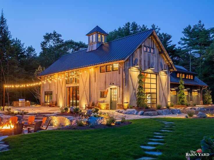 a barn with lights on the front and side of it