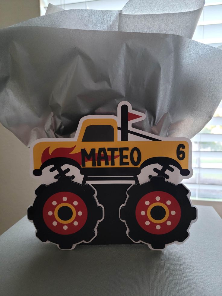 a card with a construction vehicle on it and some tissue paper in front of the card