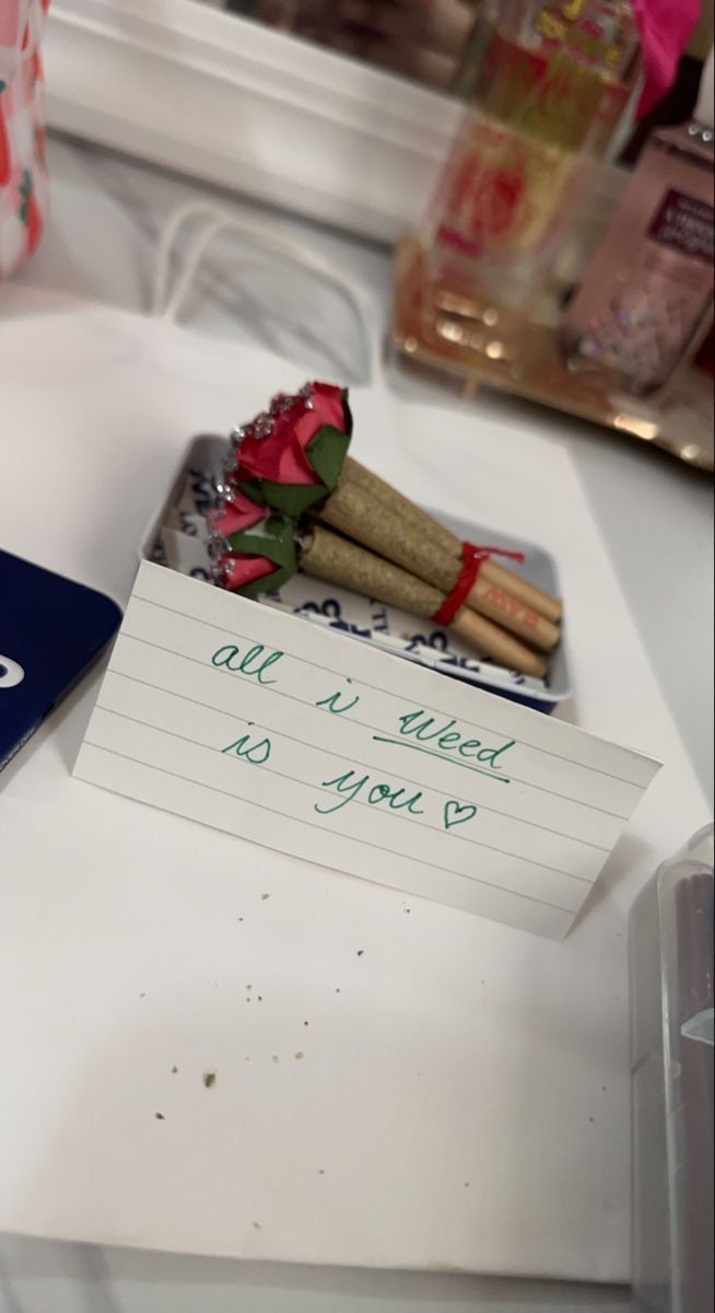 a note that says all i need is you next to some flowers on a table