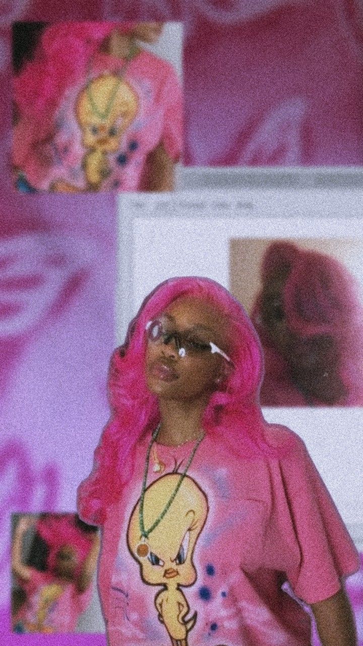 a woman with pink hair and glasses is standing in front of a computer screen that has pictures on it