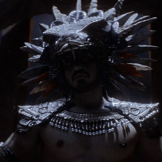 a man wearing an elaborate headdress in the dark