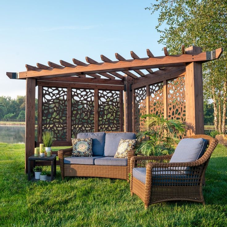 an outdoor living area with wicker furniture and pergolated arbors on the grass