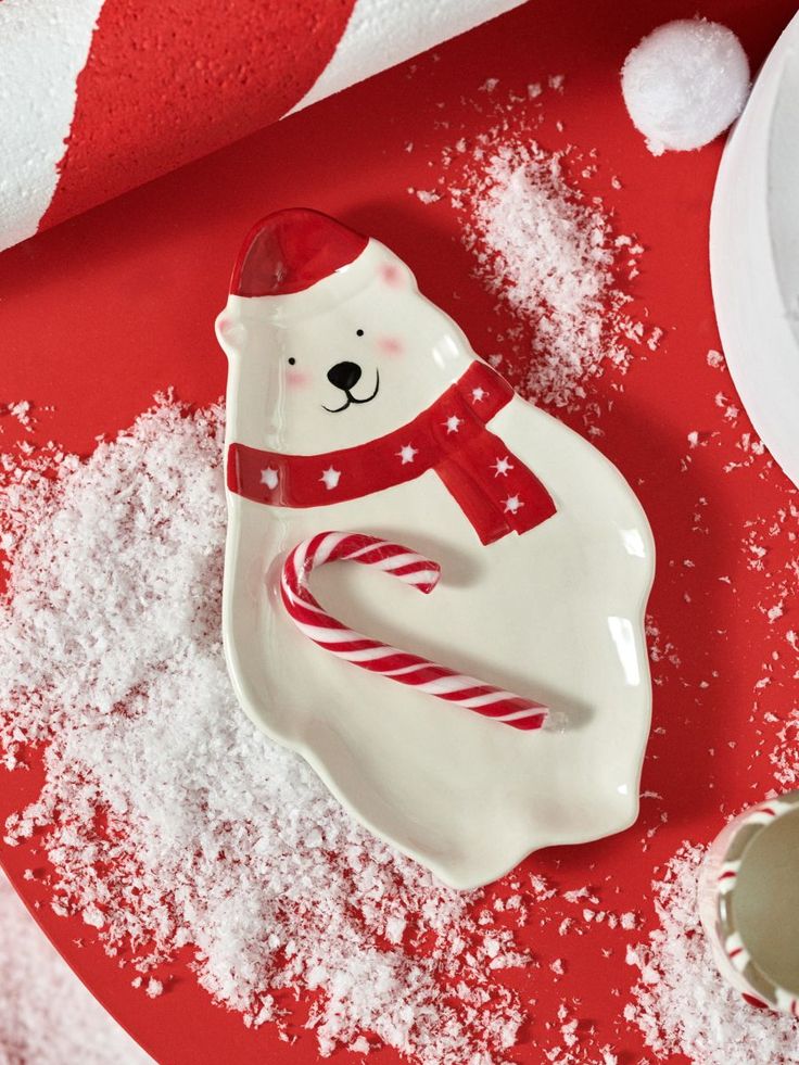 a white bear with a red scarf and candy cane