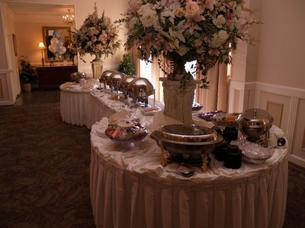 a table covered with lots of different types of desserts and flowers in vases