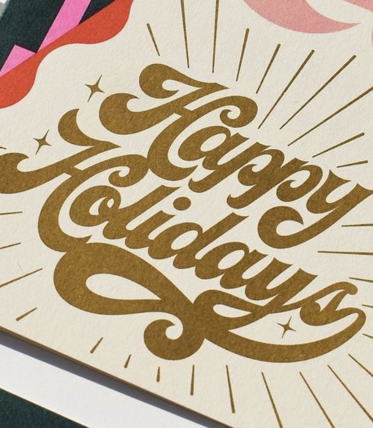 a card with the words happy holidays written in gold and pink on top of it