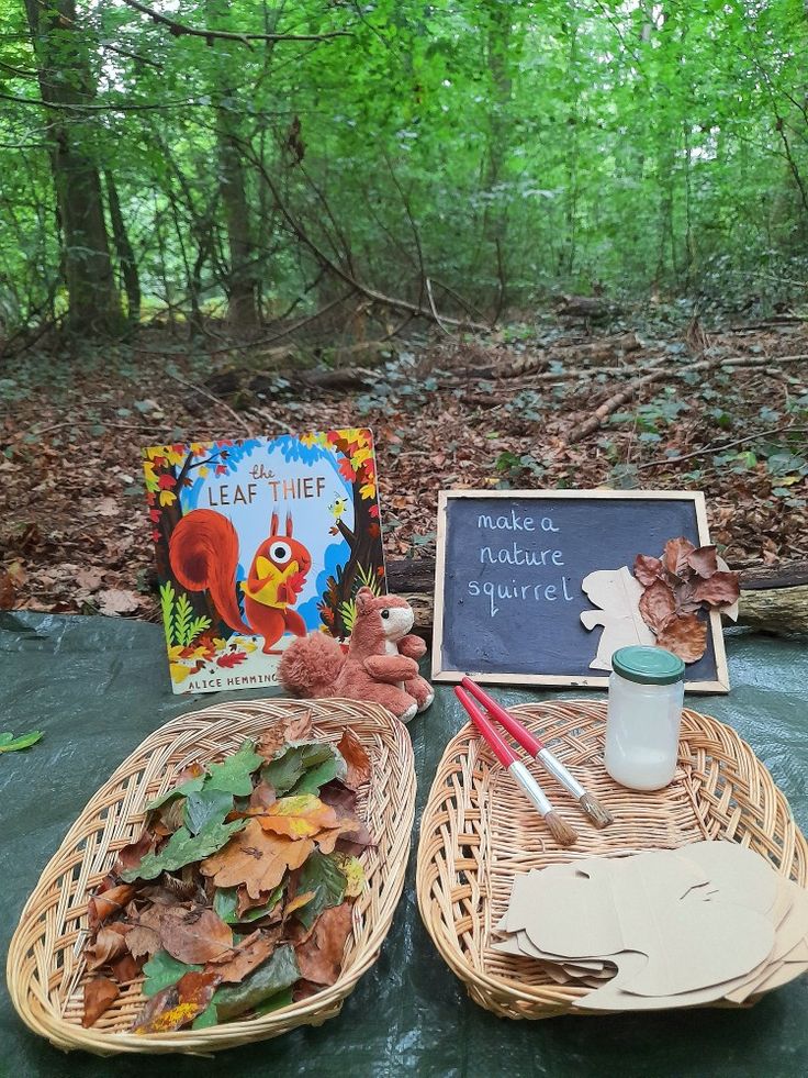 two wicker baskets filled with autumn leaves next to a chalkboard sign and book