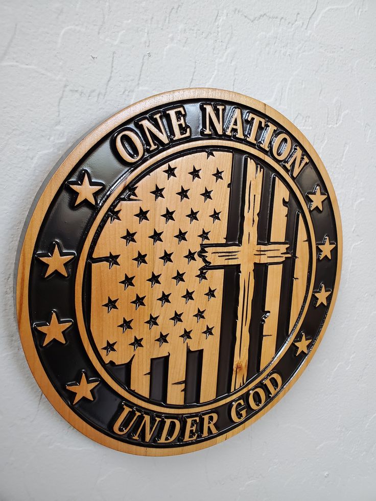 the one nation under god emblem is shown on a white wall with black stars and an american flag