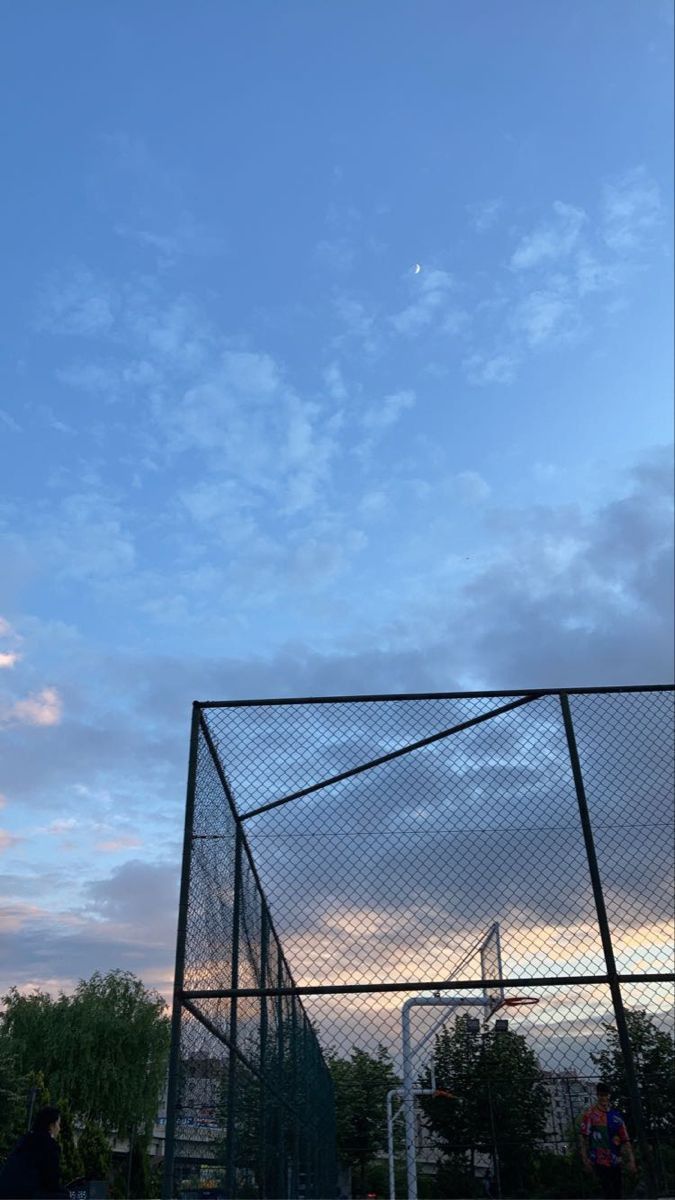 a tennis court with the sky in the background