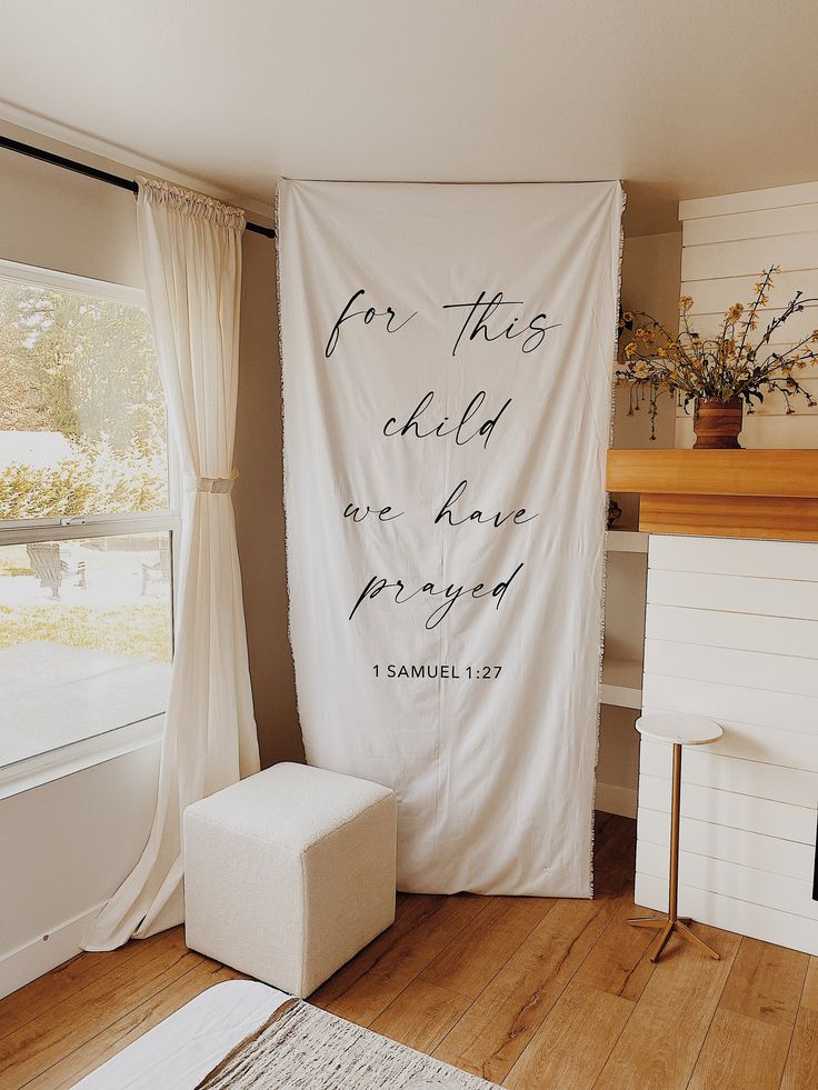 a living room with a large white banner on the wall next to a chair and fireplace