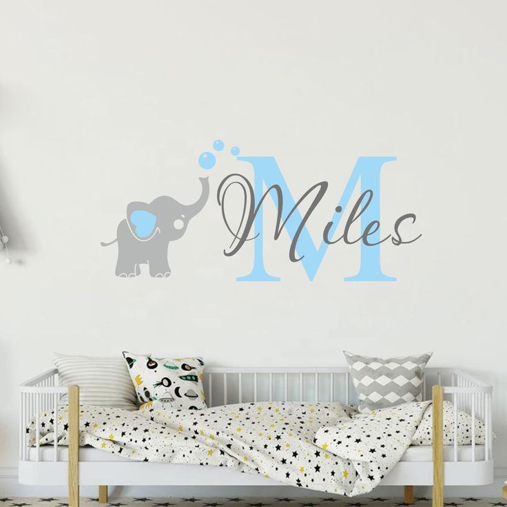 a child's bedroom with an elephant and name wall decal