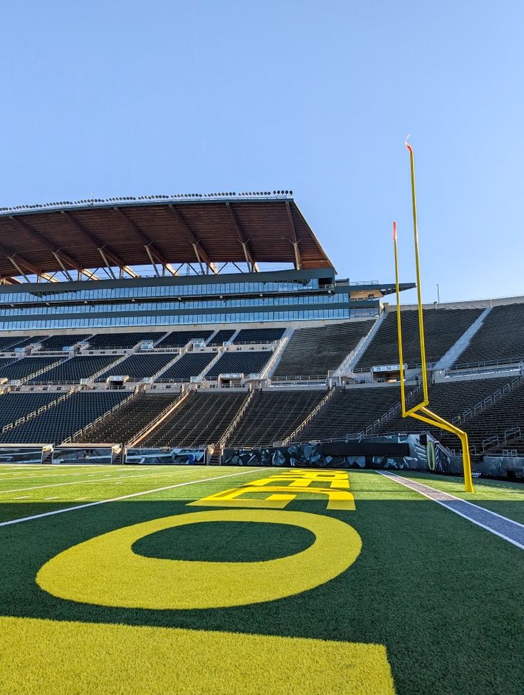 an empty football stadium with green and yellow turf