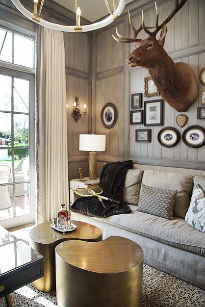 a living room filled with lots of furniture and pictures on the wall next to a window