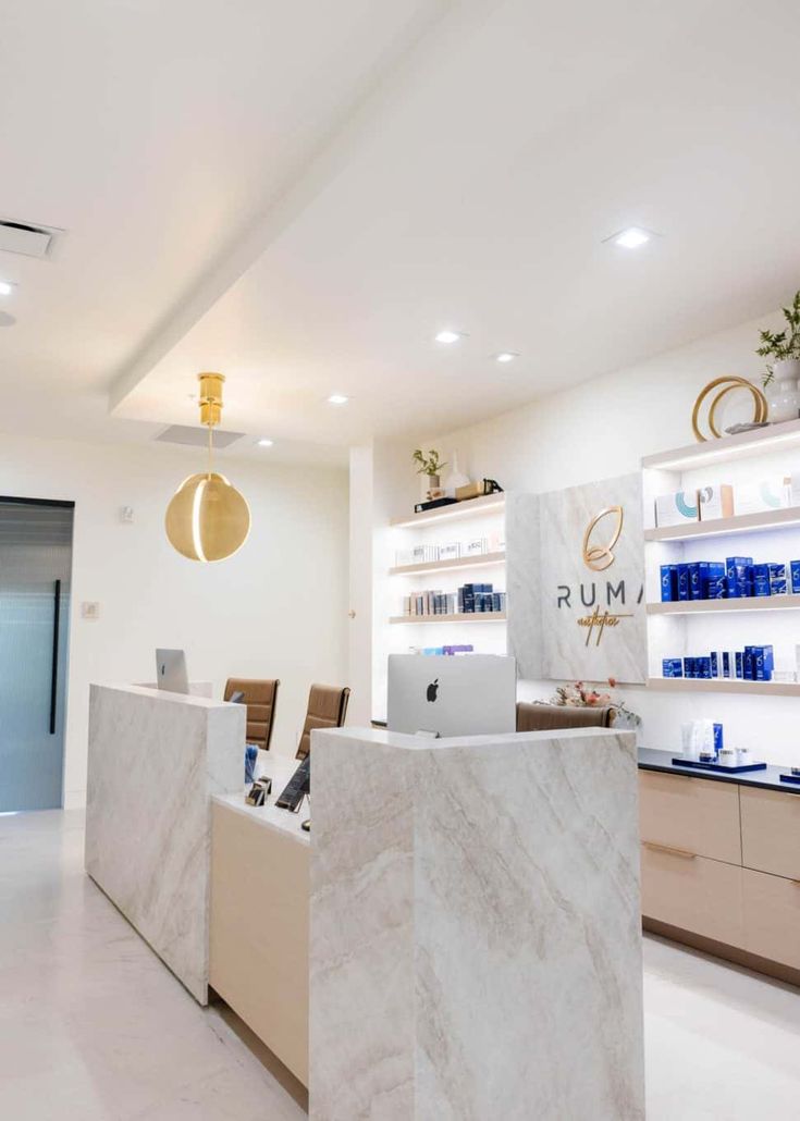 an office with marble counter tops and shelves