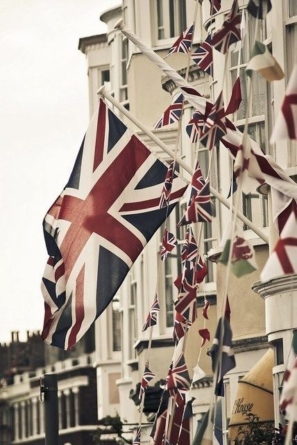 many british flags are hanging on the side of a building