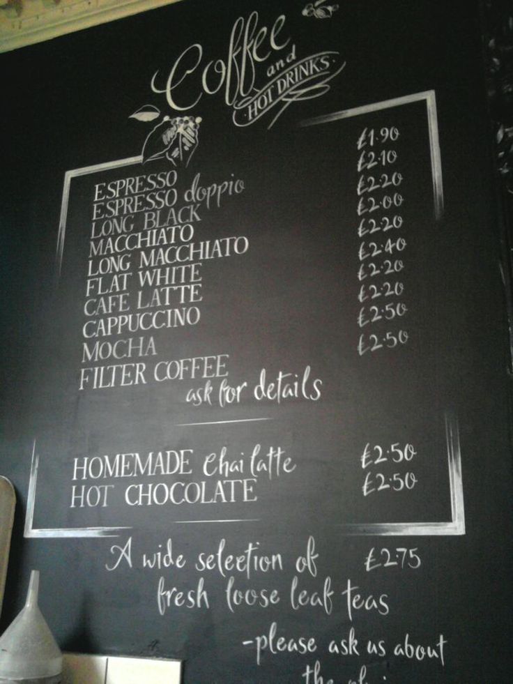 the menu for coffee is written on a blackboard