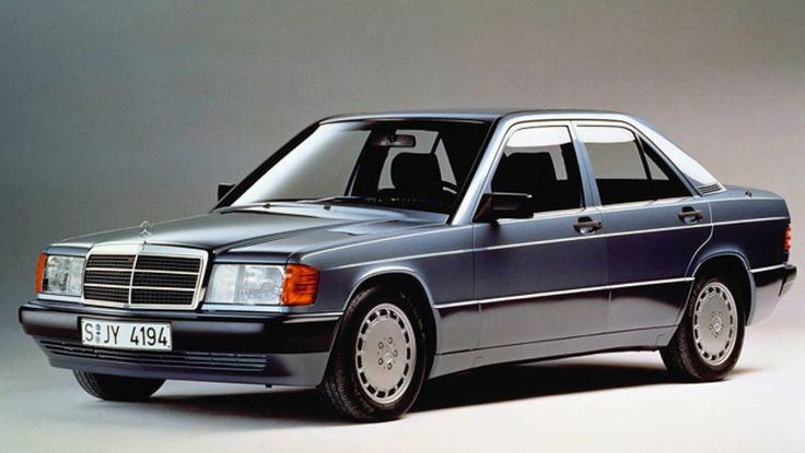 an old mercedes benz parked in front of a gray background