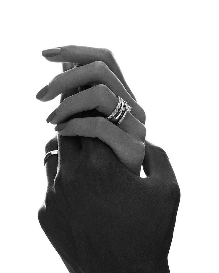 two hands holding onto each other with wedding rings on their fingers in black and white